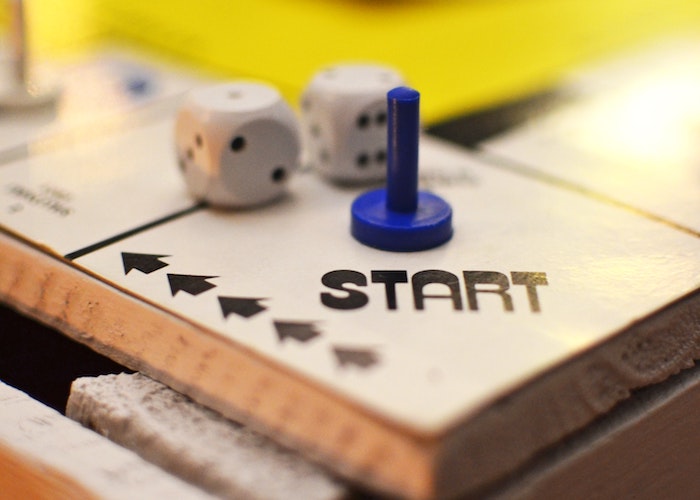 Beginning position in a board game; there are dice on the start position and pieces in the background