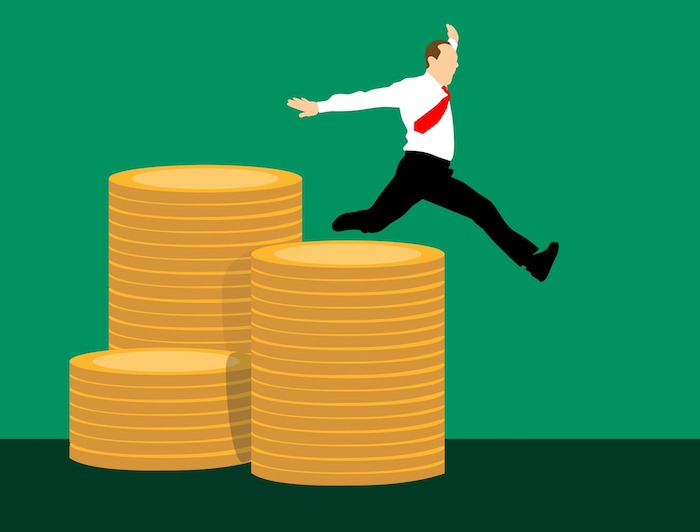 Joyful savings - illustration of a businessman leaping off stacks of coins
