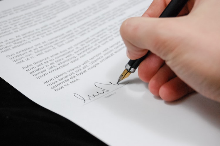 Hand signing a will.